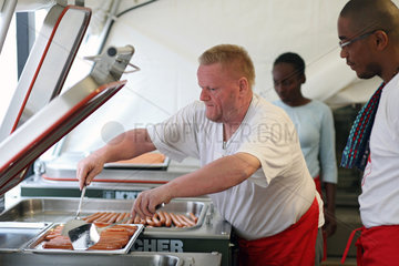Carrefour  Haiti  ein Koch des Deutschen Roten Kreuzes macht Wuerstchen warm