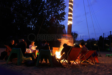 Berlin  Deutschland  Besucher einer Strandbar sitzen am Lagerfeuer