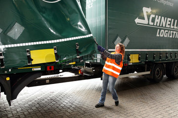 Braunschweig  Deutschland  Truckerin zieht die Plane des Lkws zur Seite um beladen zu koennen
