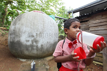 Ambalangoda  Sri Lanka  ein Junge trinkt gefiltertes Regenwasser