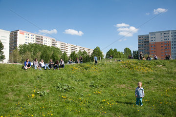 Berlin  Deutschland  Bewohner sitzen auf einem Rasenhuegel in Hohenschoenhausen