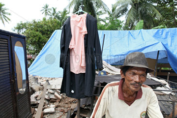 Sungai Rambai  Indonesien  ein betroffener aelterer Mann vor seinem zerstoertem Haus
