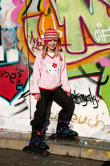Berlin  Deutschland  ein junges Maedchen vor einer mit Graffiti bemalten Wand