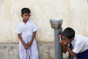 Navatkerny  Sri Lanka  ein Junge trinkt sauberes Trinkwasser von einer Wasserpumpe