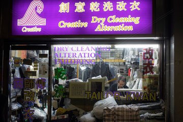 Hongkong  China  ein Mann sitzt im Schaufenster einer Waescherei
