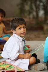 Vijayawada  Indien  ein Schueler mit Tafel beim Unterricht