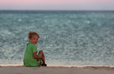 Santa Margherita di Pula  Italien  Junge sitzt alleine am Strand