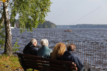 Berlin  Deutschland  Besucher sitzen auf einer Parkbank am Langen See