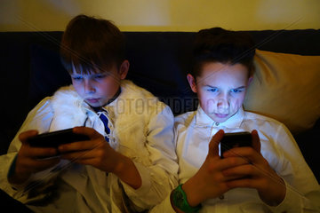 Berlin  Deutschland  zwei Jungen schauen im Dunkeln auf ihre Smartphones