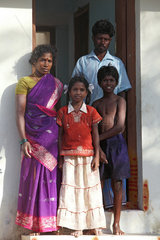 Kokilamedu  Indien  eine Familie steht vor ihrem neuem Haus