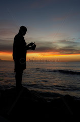 Holetown  Barbados  ein Mann fischt nur mit Schnur und Haken  Sunset Crest Beach