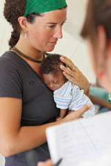 Carrefour  Haiti  Rot Kreuz Aerztin haelt ein Baby im Arm im Field Hospital