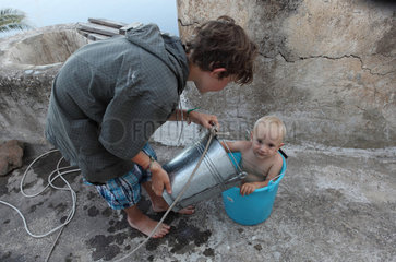 Alicudi  Italien  Kind sitzt in einem Eimer mit Wasser