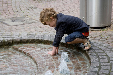 Rinteln  Deutschland  Junge spielt im Brunnen auf dem Marktplatz von Rinteln
