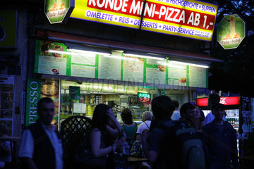 Berlin  Deutschland  Gaeste vor einem Imbiss fuer Mini-Pizza am Schlesischen Tor