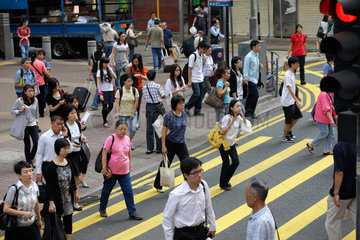 Hongkong  China  Passanten ueberqueren einen Zebrastreifen in Hongkong Wan Chai
