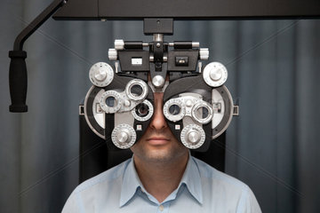 Deutschland  Mann beim Sehtest beim Augenarzt