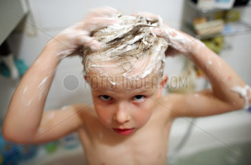 Junge waescht sich die Haare