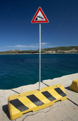 Palau  Italien  ein Hinweisschild fuer das ungesicherte Ufer auf einer Mole in Palau an der Costa Smeralda auf Sardinien