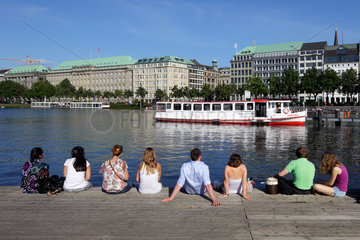 Hamburg  Deutschland  Menschen sitzen auf einem Steg an der Binnenalster