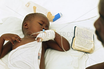 Carrefour  Haiti  ein kranker Junge  daneben eine aufgeschlagene Bibel