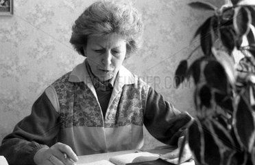 Berlin  DDR  Frau sitzt an einem Schreibtisch und blaettert in einem Terminplaner