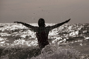 Kaegsdorf  Deutschland  Silhouette  Frau springt aus dem Meer heraus