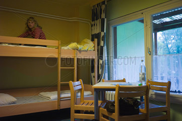 Bad Saarow  Deutschland  ein Maedchen hockt auf einem Bett in einer Jugendherberge