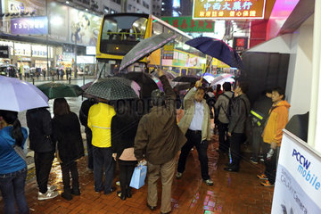 Hong Kong  China  Menschen stehen bei Regen an einer Bushaltestelle