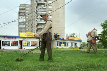 Lemberg  Ukraine  staedtische Angestellte maehen den Rasen vor einer Hochhaussiedlung