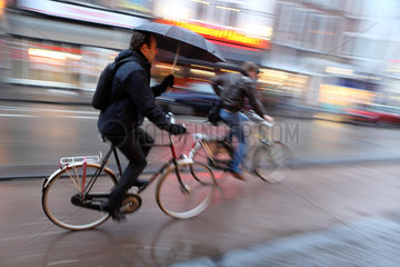 Utrecht  Niederlande  Fahrradfahrer bei Regen auf der Strasse