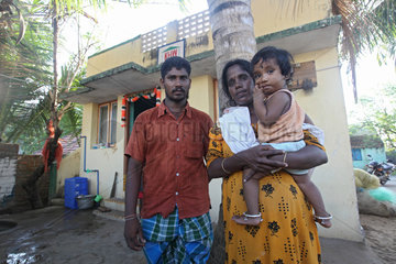 Alikuppam  Indien  eine Familie vor einem neugebauten Wohnhaus