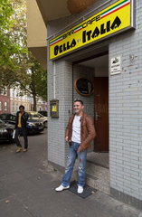 Dortmund  Deutschland  junger Mann italienischer Herkunft vor dem italienischem Cafe Bella Italia