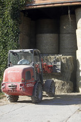 Gestuet Goerlsdorf  Heuballen werden mit einem Traktor in einer Scheune abgeladen