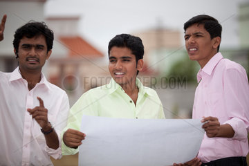 Coimbatore  Indien  junge indische Geschaeftsmaenner mit Bauplan
