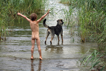 Usedom  Deutschland  Nackter Junge und ein Hund stehen im Wasser