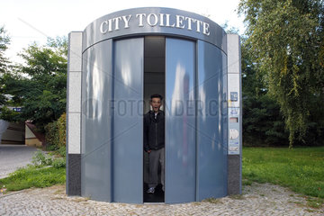 Berlin  Deutschland  Junge kommt aus einer oeffentlichen Toilette heraus