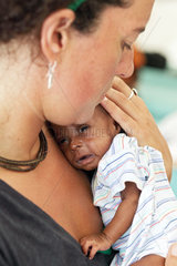 Carrefour  Haiti  Rot Kreuz Aerztin haelt ein Baby im Arm im Field Hospital