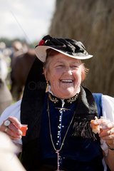 Sankt Maergen  Deutschland  eine Frau in Tracht feiert froehlich auf dem Rossfest