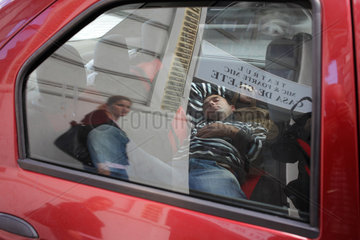 Bukarest  Rumaenien  ein Mann schlaeft auf der Rueckbank seines Autos