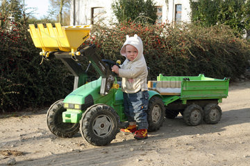 Prangendorf  Kleinkind spielt mit einem Spielzeugtraktor