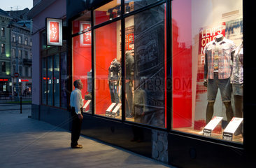 Lemberg  Polen  Mann betrachtet Schaufenster eines Geschaefts der amerikanischen Jeansmarke Levis