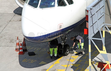 Berlin  Deutschland  Flughafenmitarbeiter entfernen die Bremskloetze an einem Flugzeug