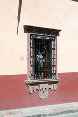 San Miguel de Allende  Mexiko  eine Frau putzt die Schutzgitter eines grossen Fensters