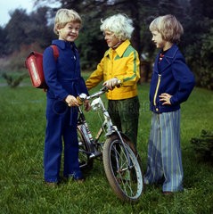 Berlin  Deutsche Demokratische Republik  Vorschulkinder stehen mit einem Fahrrad auf einer Wiese