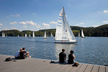 Essen  Deutschland  Segelboote auf dem Baldeneysee und Menschen am Bootssteg
