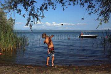Bolsena  Italien  Junge wirft einen Stein in den Bolsenasee