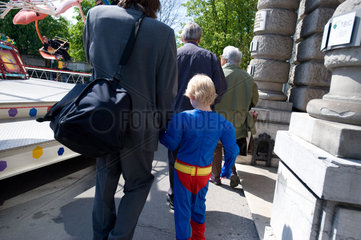 Zuerich  Schweiz  Vater und Sohn gehen an einem Fahrgeschaeft vorbei