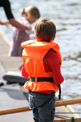 Berlin  Deutschland  Kind steht mit Schwimmweste auf einem Bootssteg