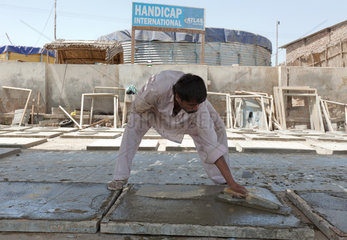 Thatta  Pakistan  Menschen giessen Bodenplatten fuer Latrinen